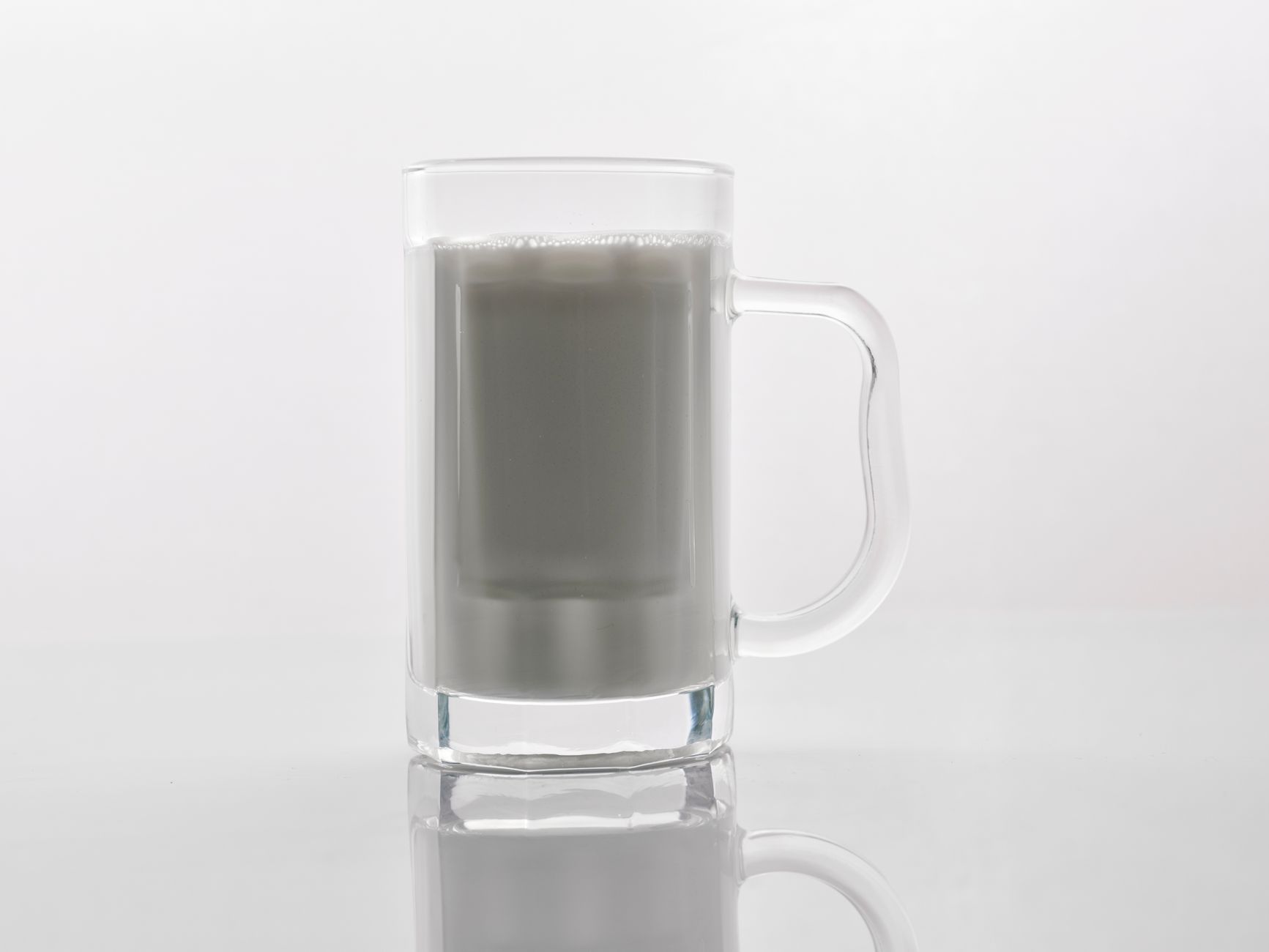 Close-up of a glass mug filled with milk against a white background, ideal for beverage-related themes.