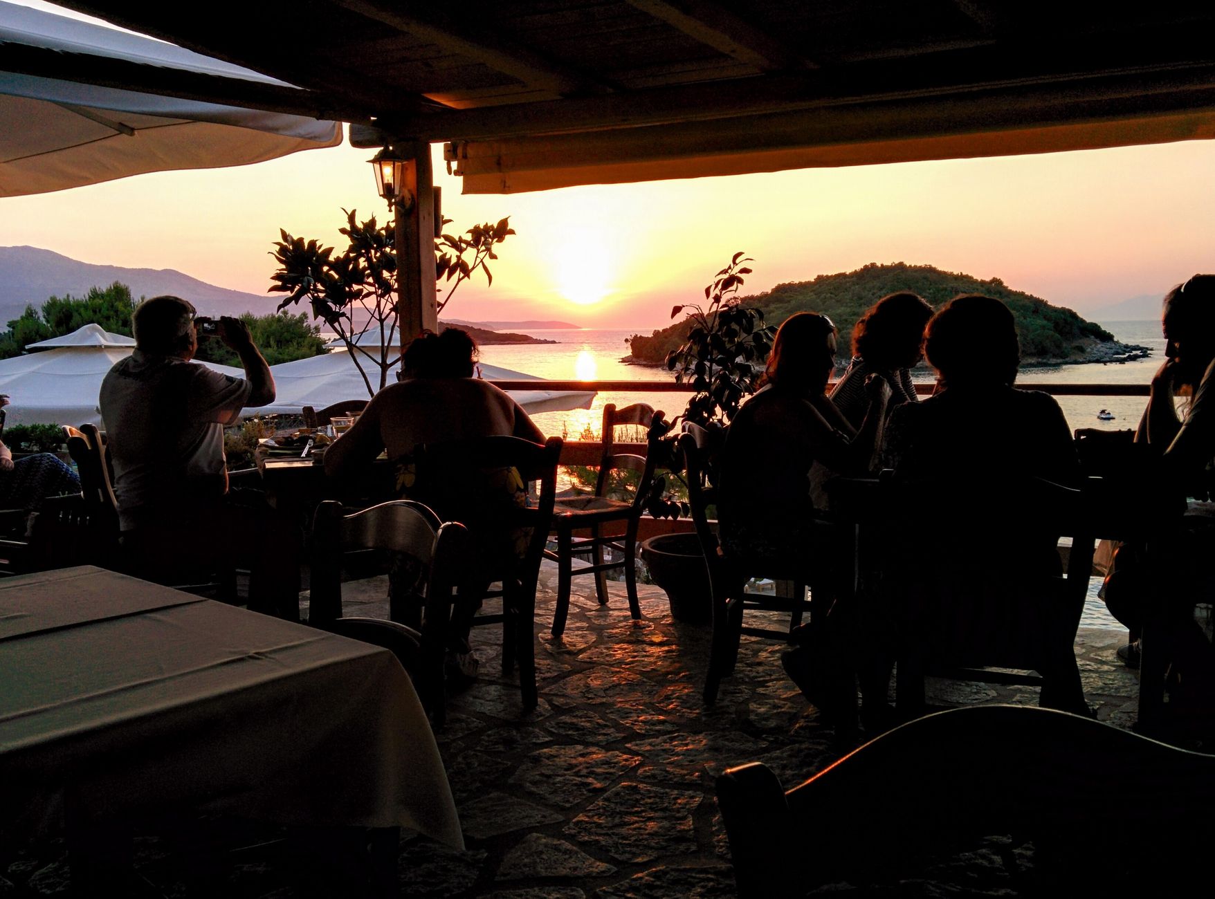 Elegant seaside dining in Ksamil, Albania during a vibrant sunset.