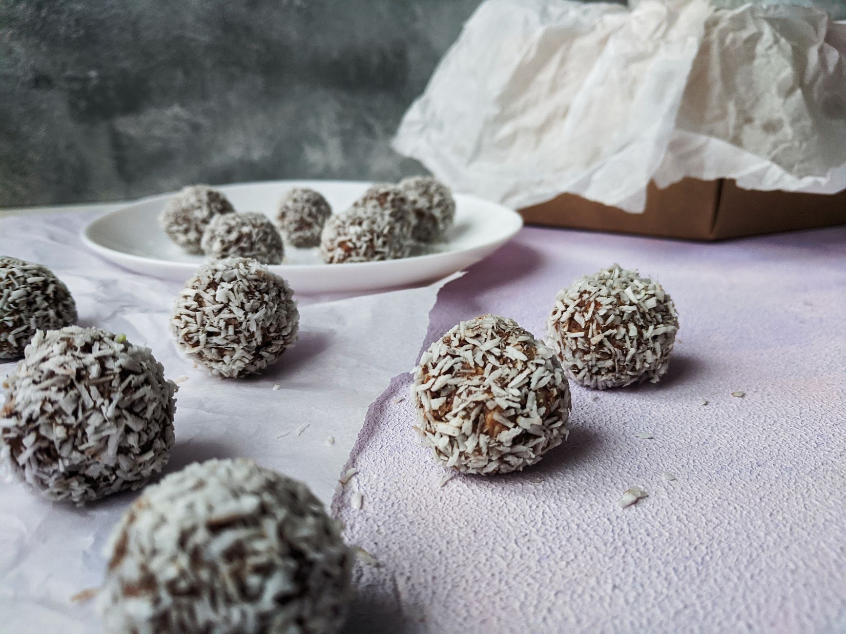Delicious homemade chocolate truffles coated with coconut flakes, beautifully arranged on decorative paper.