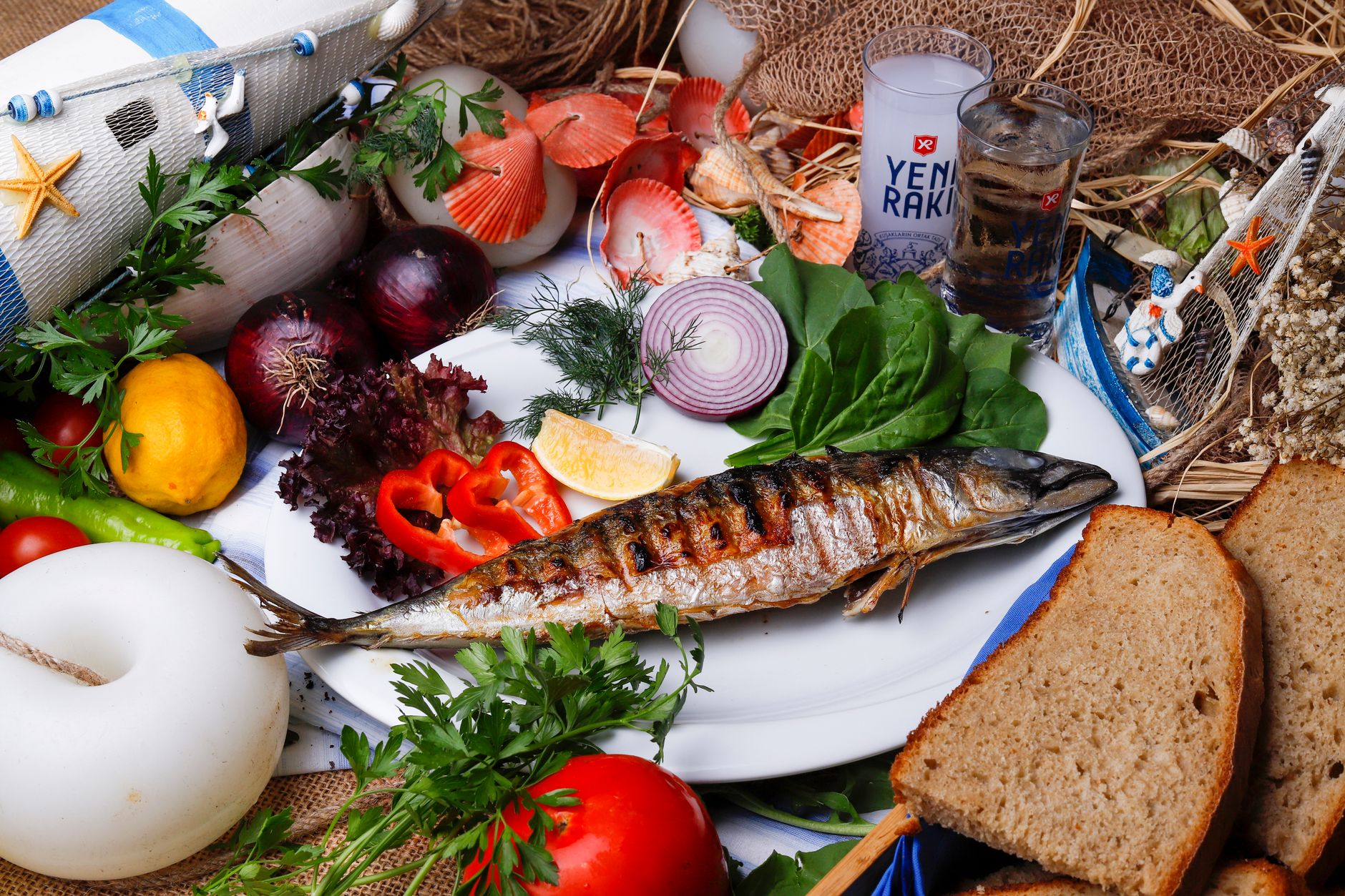 Delicious grilled fish served with fresh Mediterranean vegetables and bread.