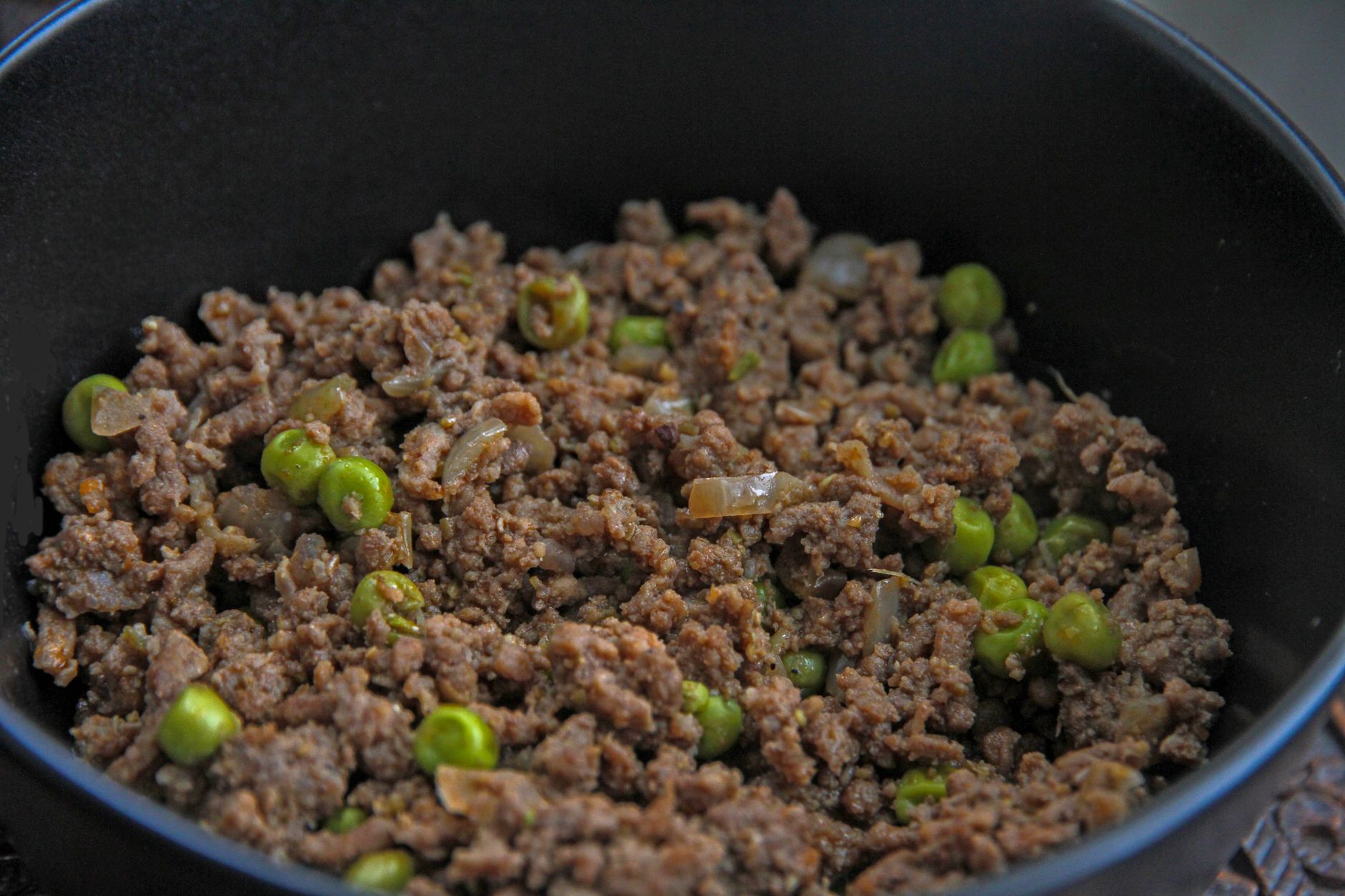 Close-up of a savory dish with minced meat and peas, ideal for culinary themes.