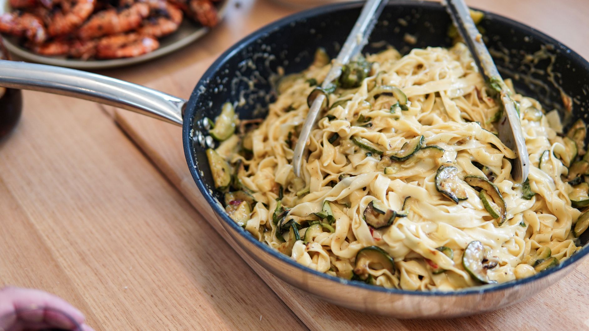 Delicious tagliatelle pasta with creamy zucchini sauce in a pan, perfect for a gourmet meal.