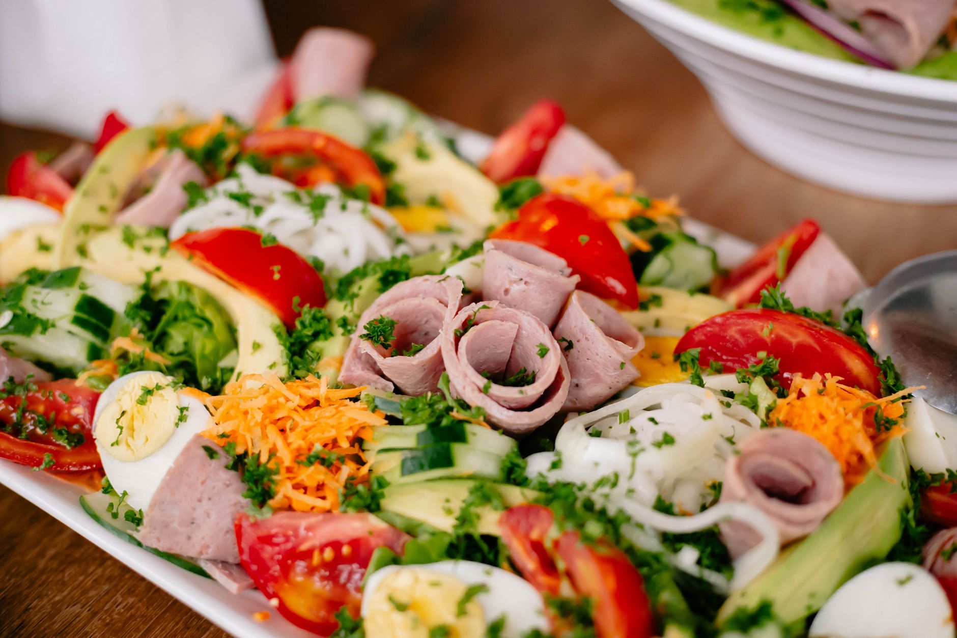 Vibrant salad with lettuce, tomatoes, ham, cheese, and eggs, perfect for a healthy meal.