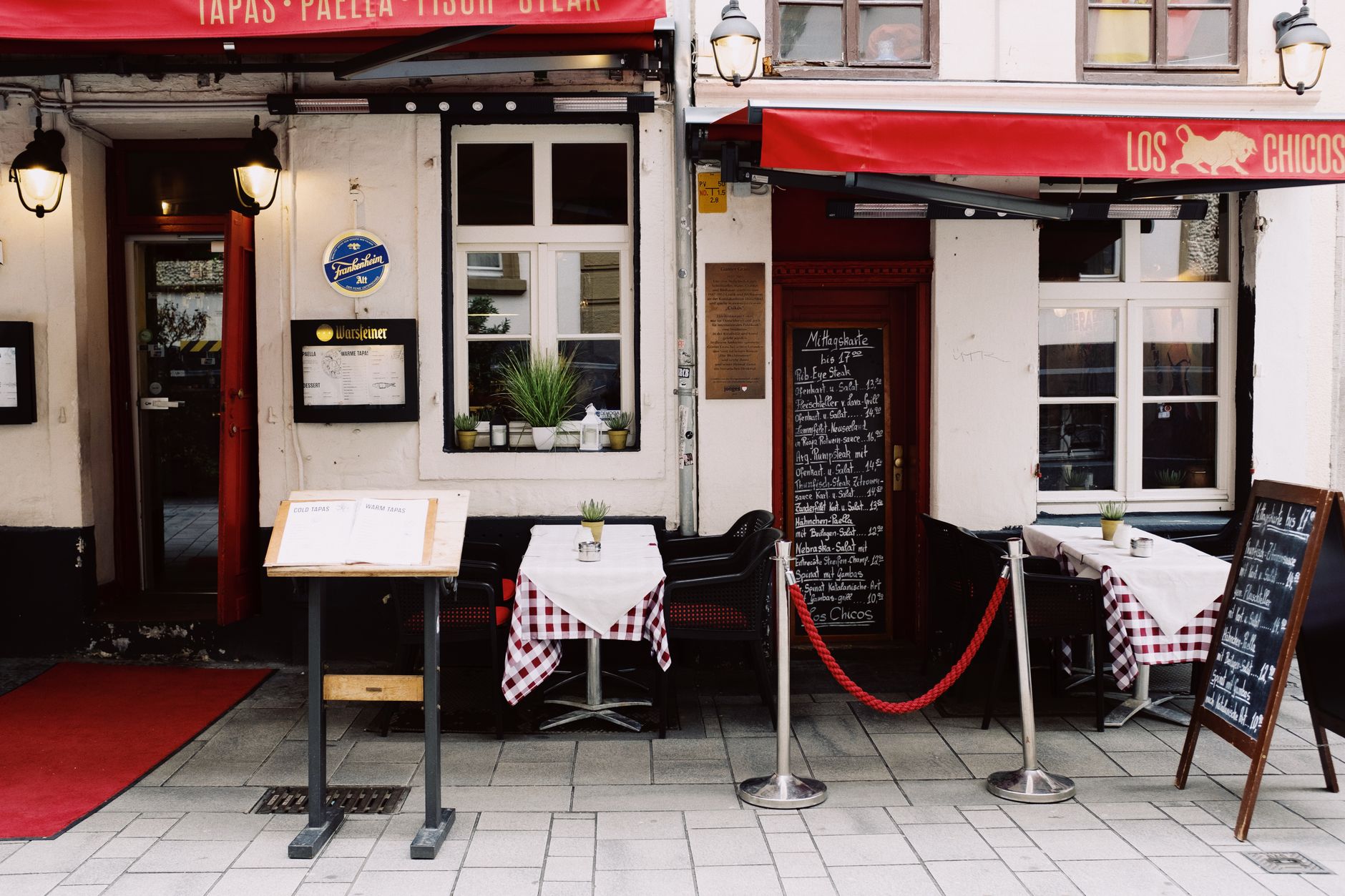 Exterior of street pub decorated with colorful signboard and menu desk located on street in city
