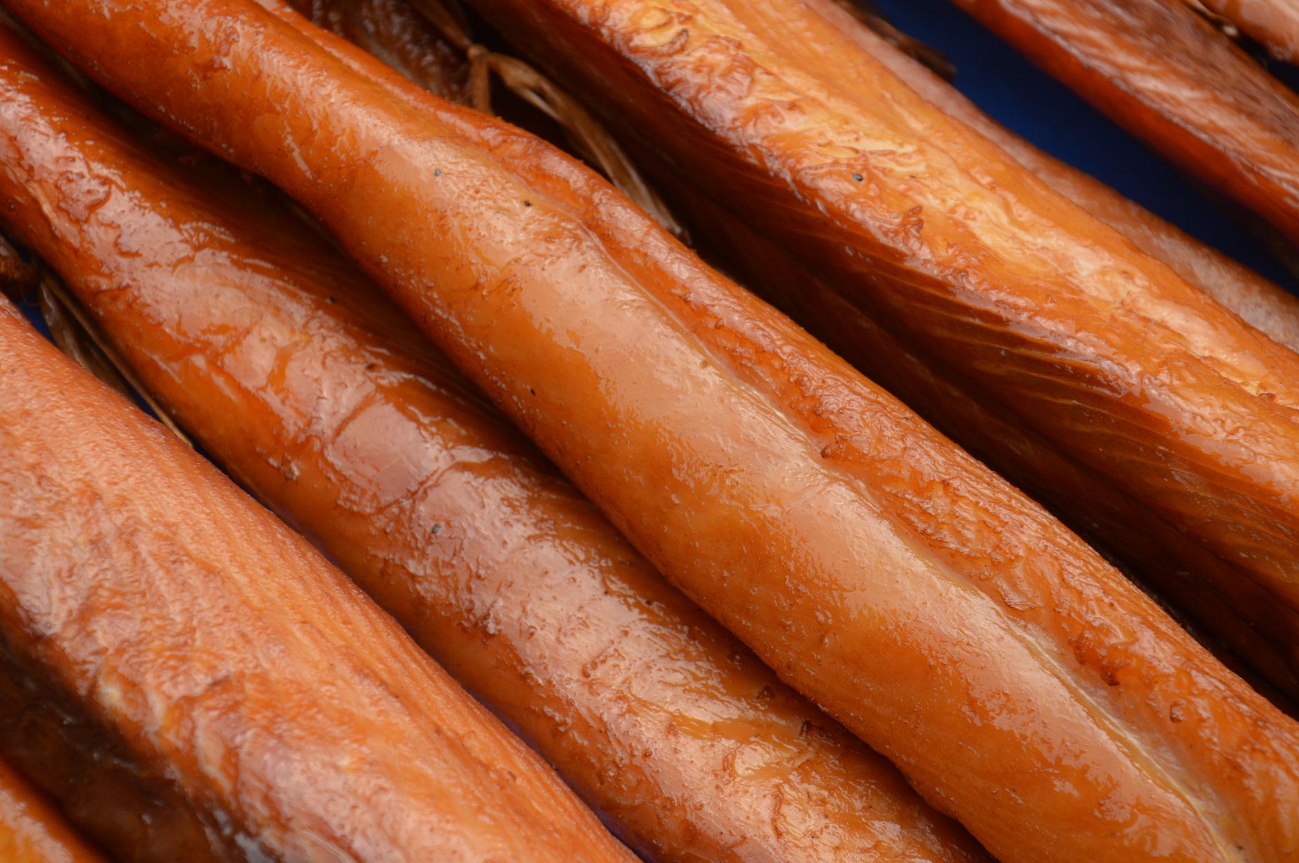 Detailed shot of smoked salmon fillets showcasing textures and rich colors.