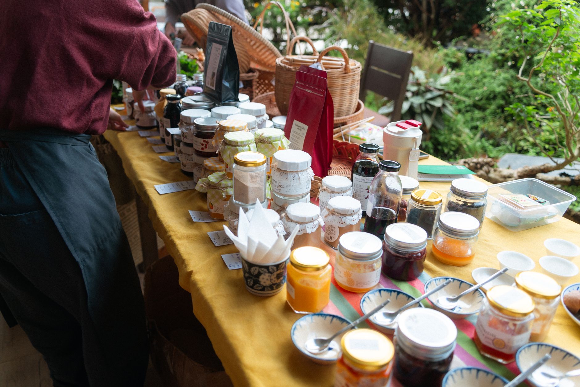 Vibrant display of jam jars and homemade goods at a rustic farmers market.