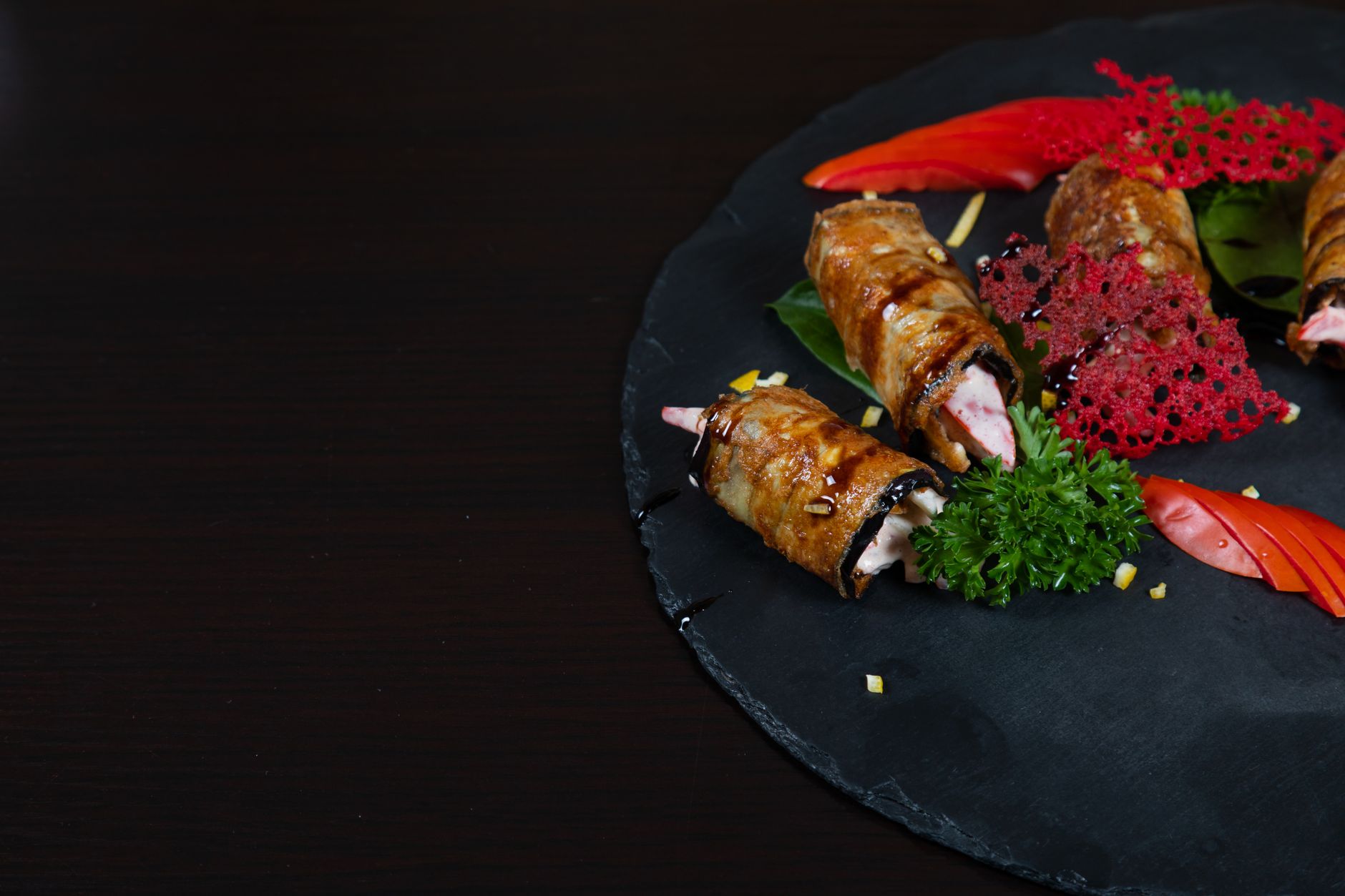 Close-up of gourmet chicken rolls garnished with vegetables for an elegant meal.