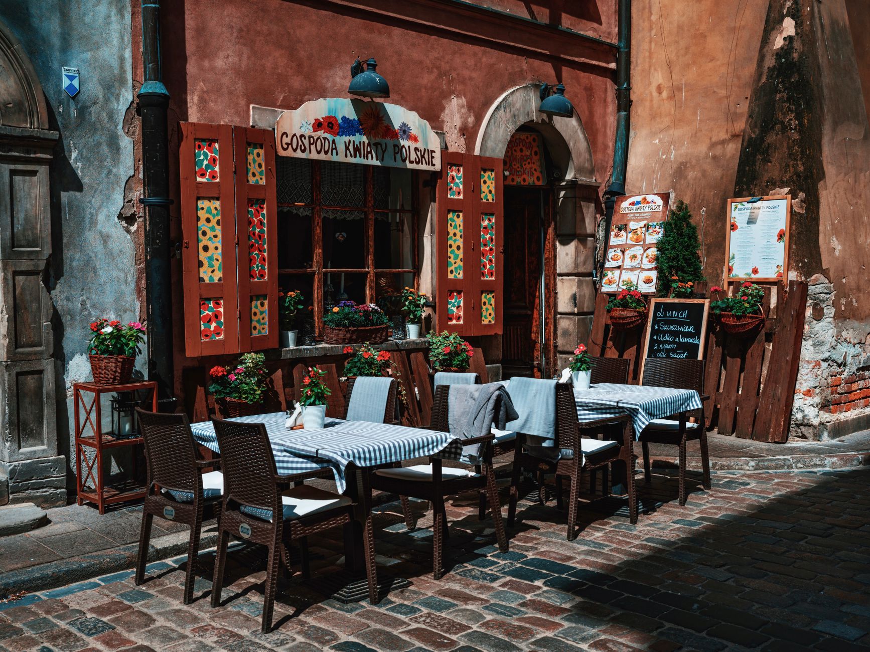 Outdoor dining area of a Polish restaurant with traditional architecture, set in a quaint old town.